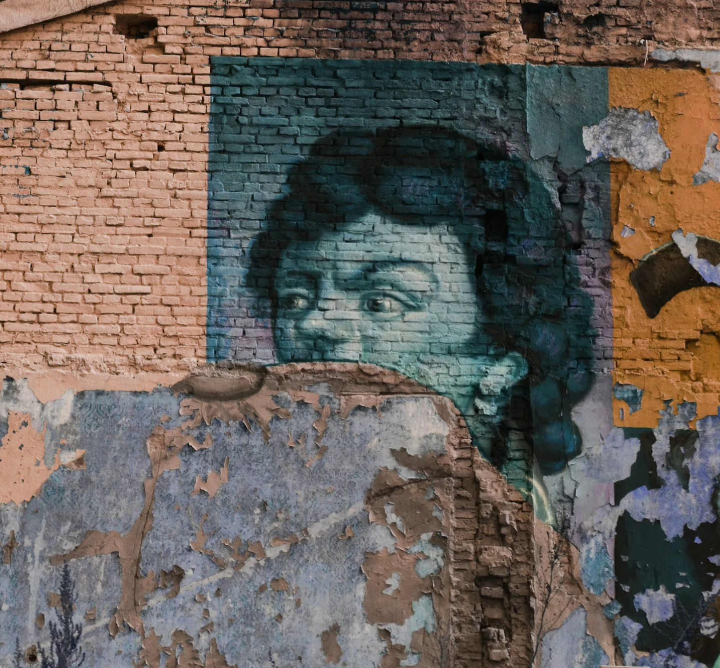 Peeling graffiti on a brick wall